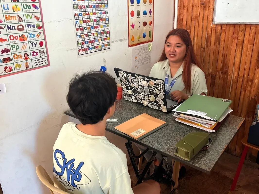 女性がノートパソコンを使いながら、少年と学習指導を行っている様子