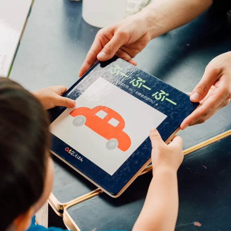 大人から子どもへ絵本を渡す様子