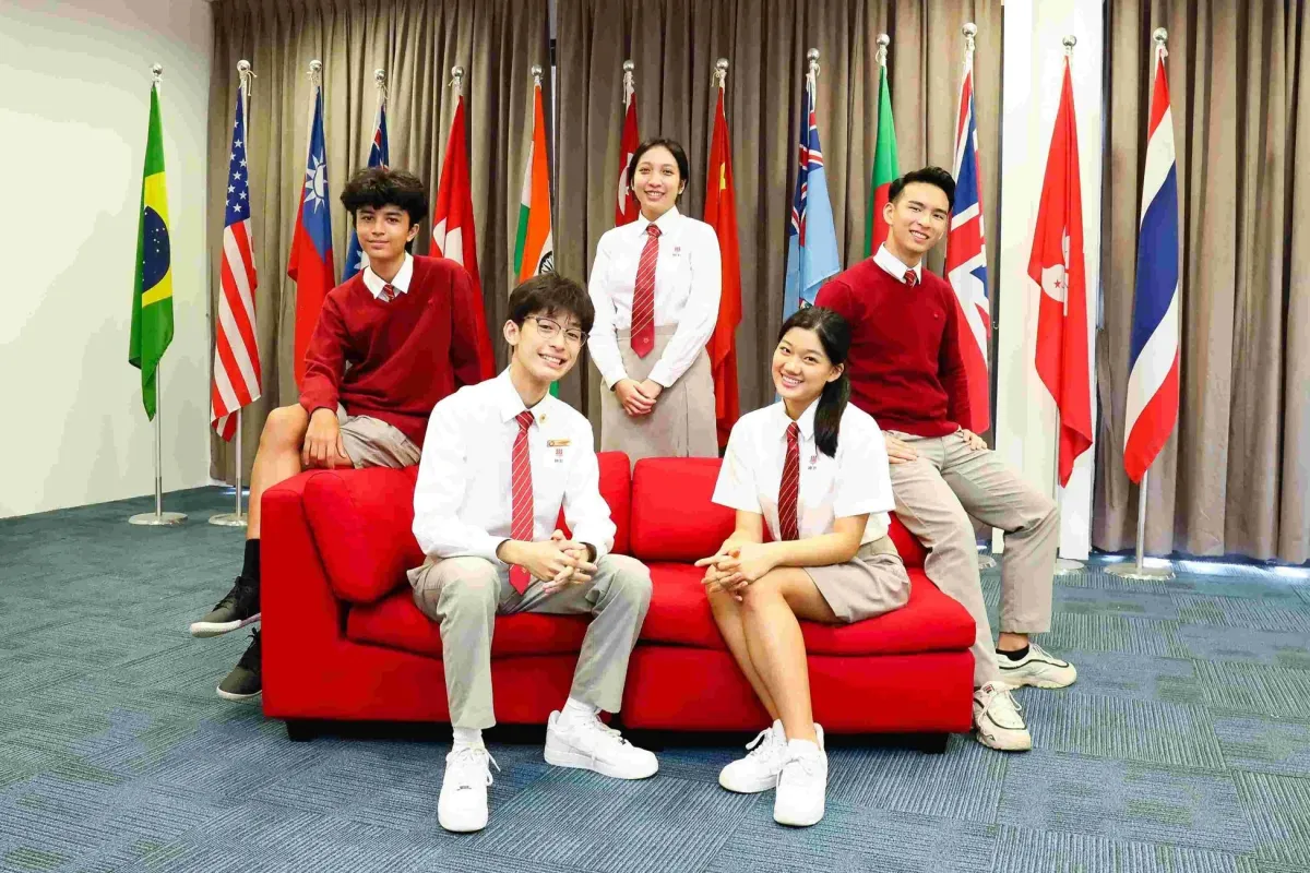 ホアチョンインターナショナルスクールの生徒たちが旗を背景に集合写真