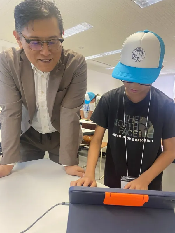 タブレットを見つめる子どもと男性