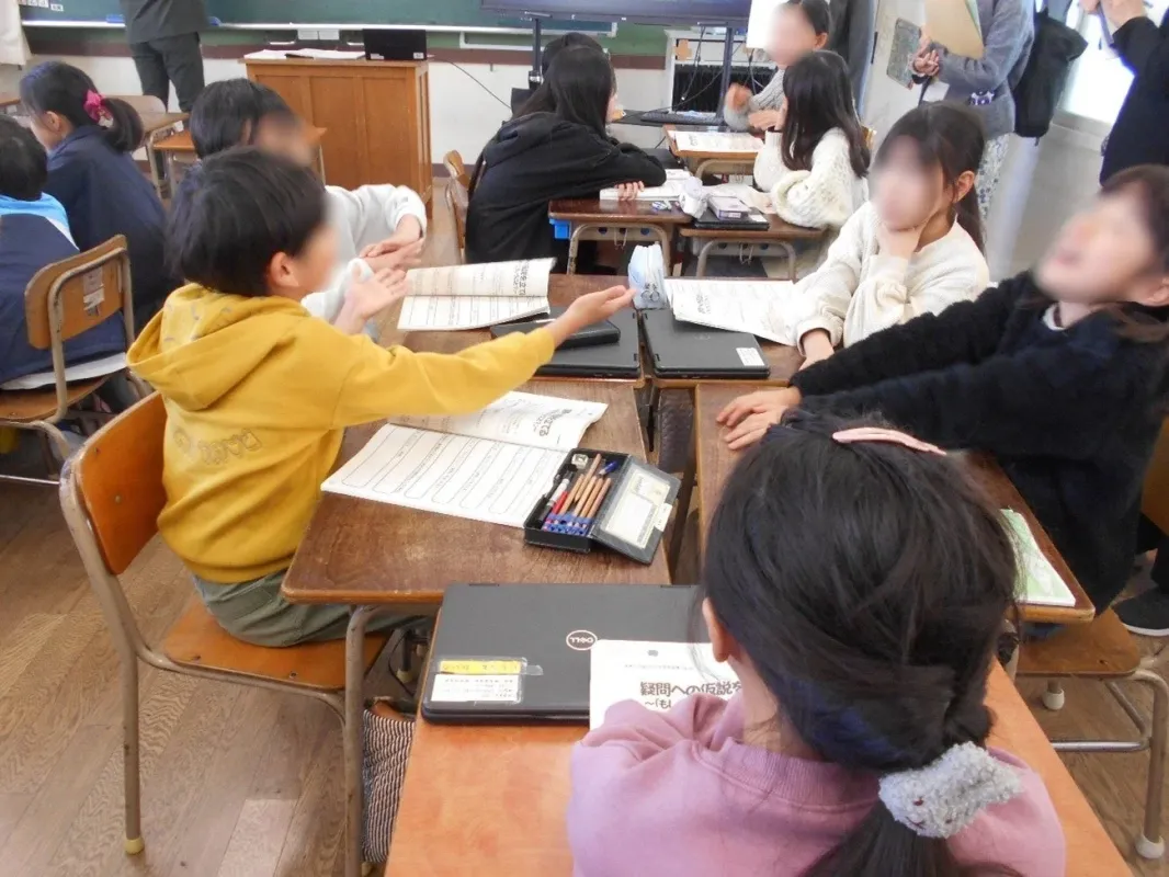 教室で小学生がグループワーク、タブレット学習
