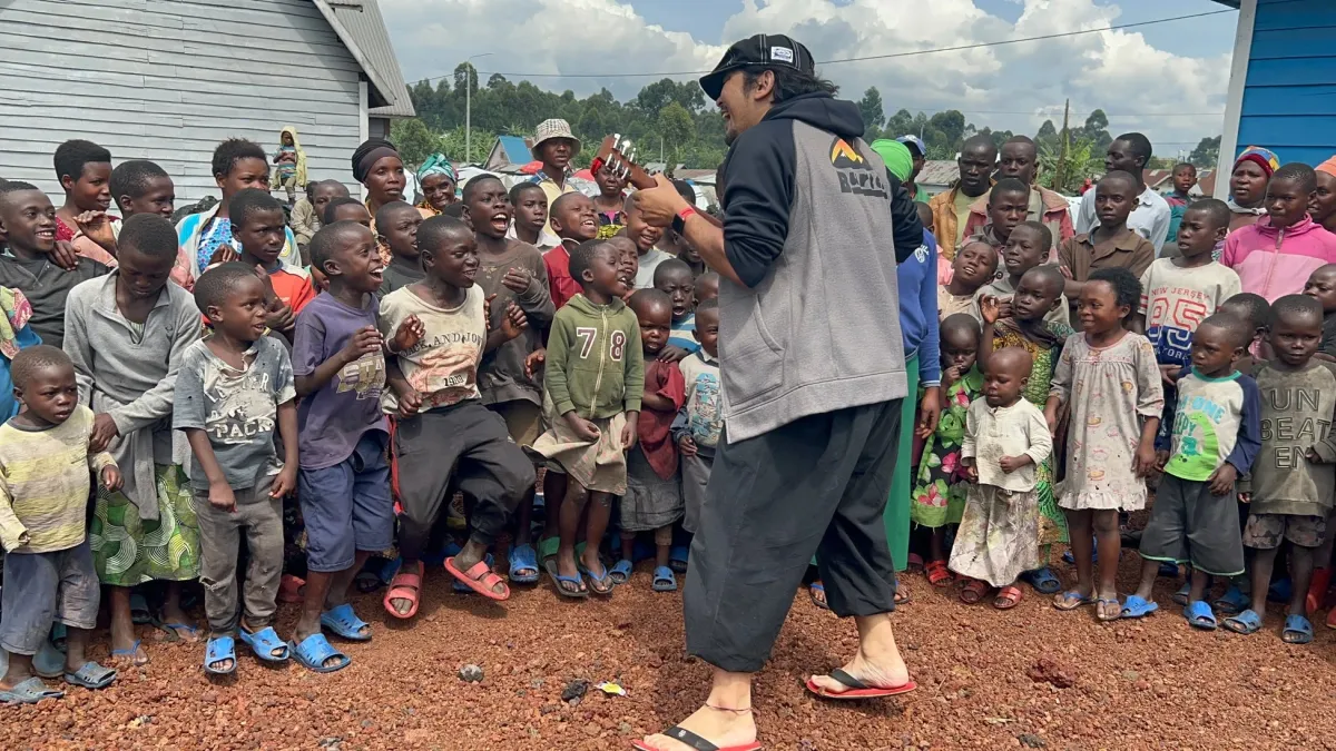 ギターを弾く男性と子供たち