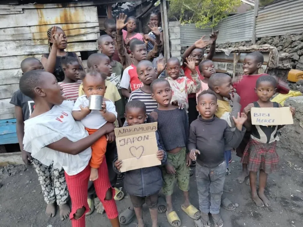 NAKAMURA JAPONと書かれた看板を持つ子供たち