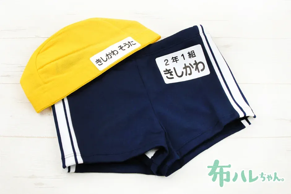 水泳帽とスクール水着に貼られた名前シール