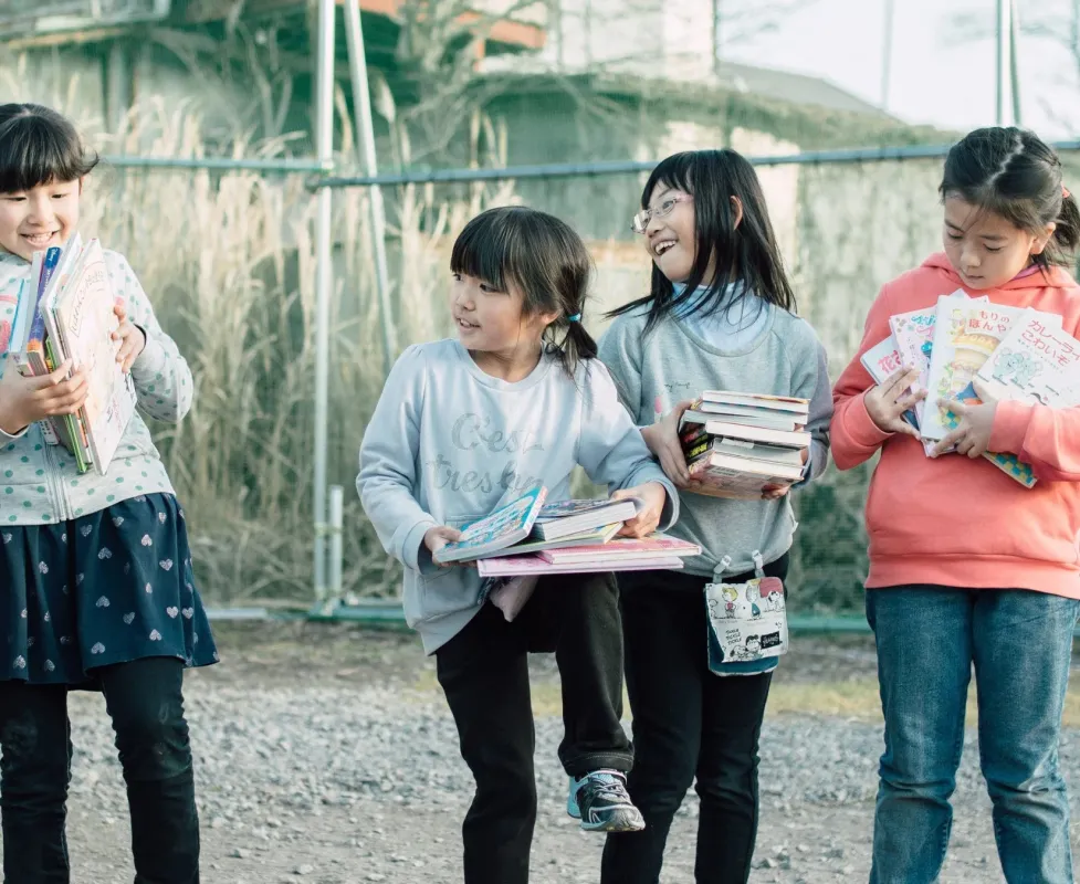 たくさんの本を抱える女の子たち