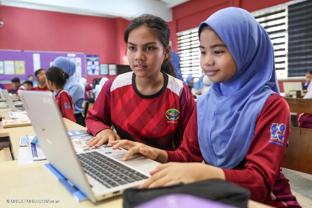 教室でラップトップを共有し学習する女子生徒