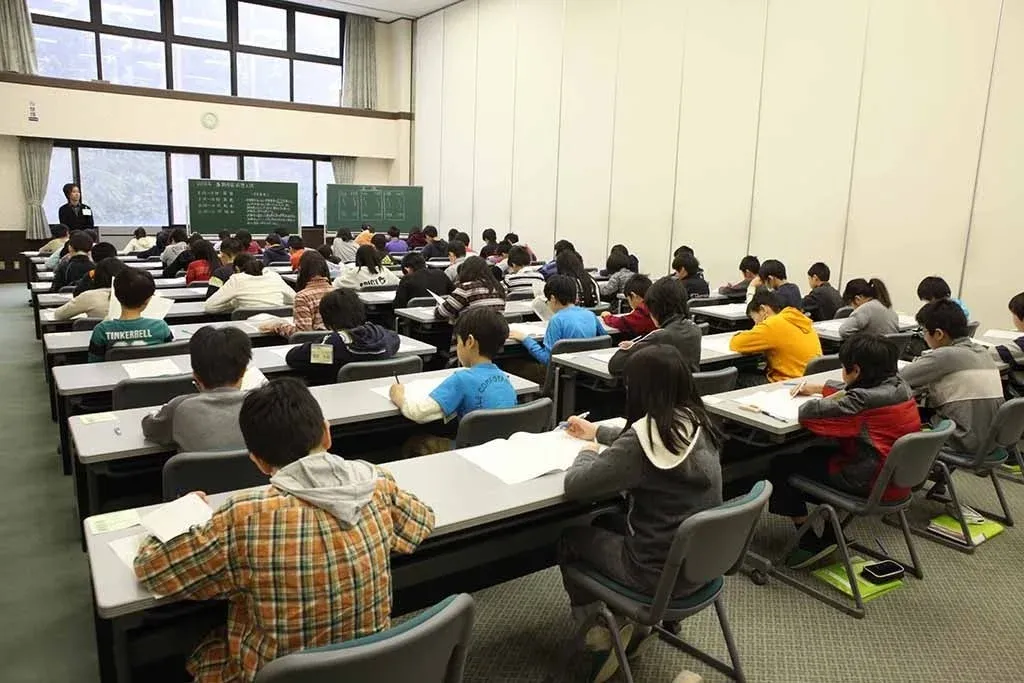 広々とした教室で多くの生徒が机に向かい学習に取り組む様子