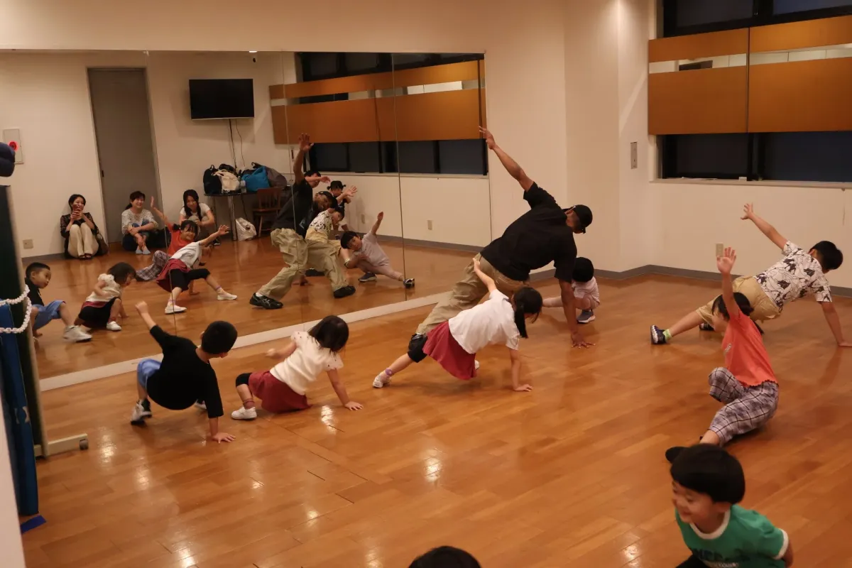 子供たちが大人と一緒にダンスやエクササイズをしている様子