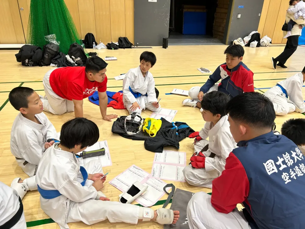 空手着姿の子供たちが集まって話し合っている様子