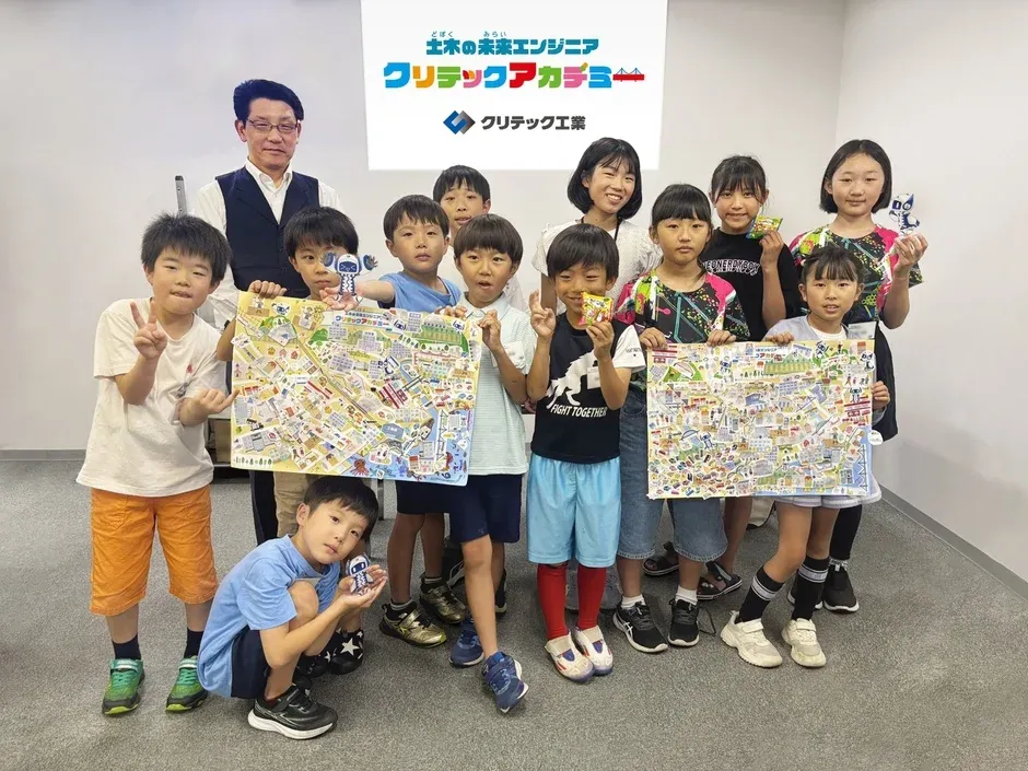 「土木の未来エンジニア クリテックアカデミー」のイベントで、子供たちと大人が集合写真を撮っている。