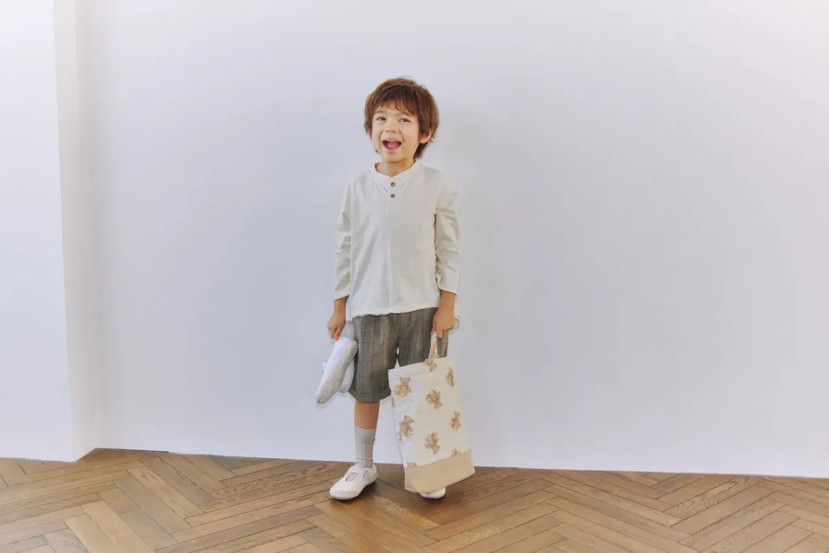 クマ柄のシューズバッグを持つ男の子