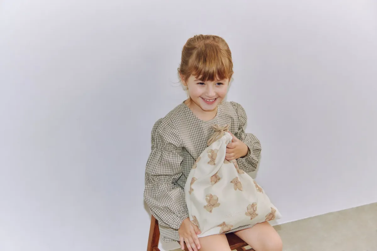 クマ柄の巾着袋を持つ女の子