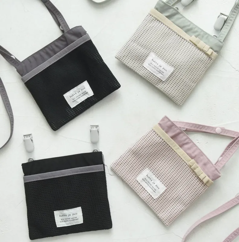 「kukka ja puu」のメッシュ素材の移動ポケットやポシェットが複数並んだ画像です。黒、ライトグレー、ライトピンクの3色があり、ストラップやクリップで多様な使い方ができる多機能なファッション小物のラインナップを紹介しています。