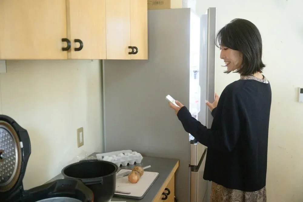 キッチンで冷蔵庫を開ける女性