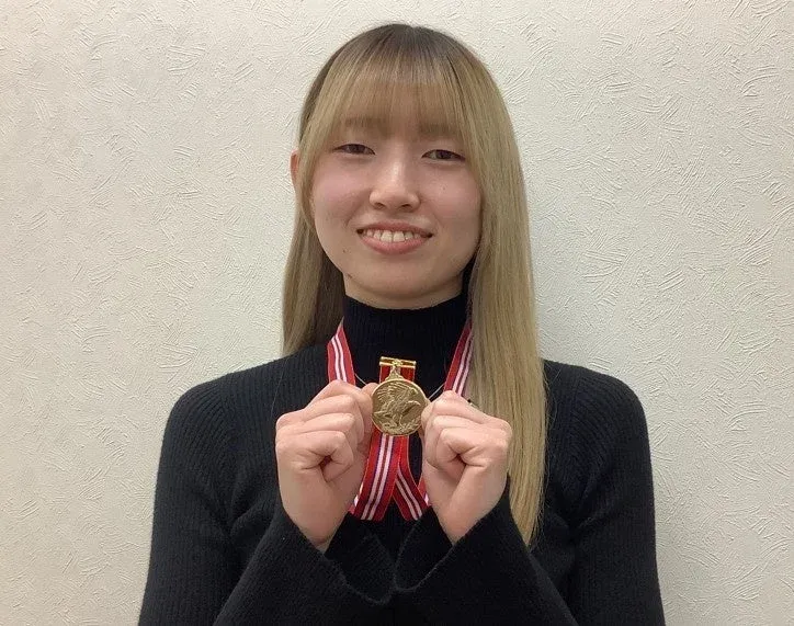 英語でのスピーチを終え、メダルを掲げる生徒さん