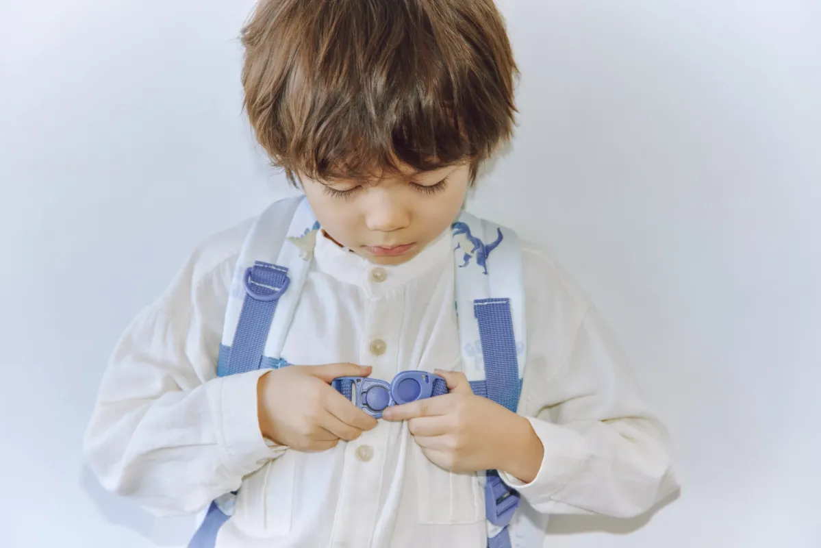 リュックのバックルを留める男の子