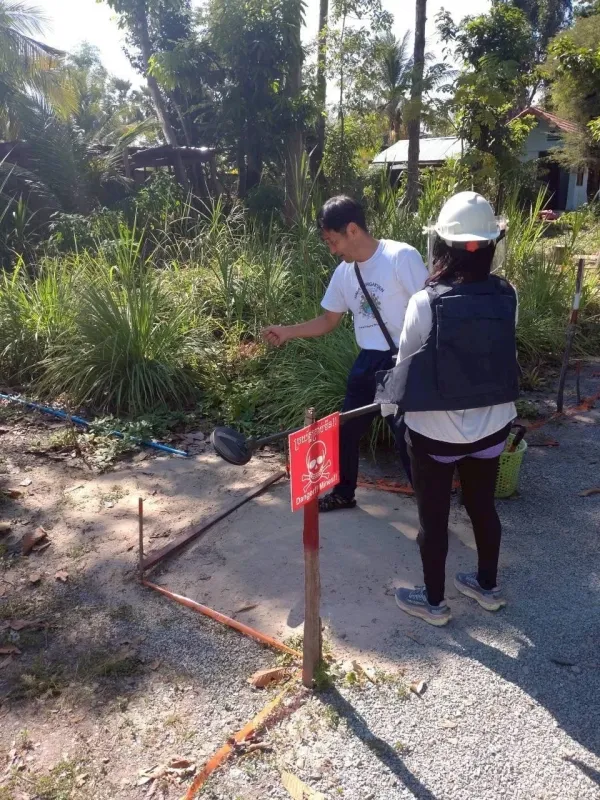 「地雷注意」の標識と地雷除去作業の様子