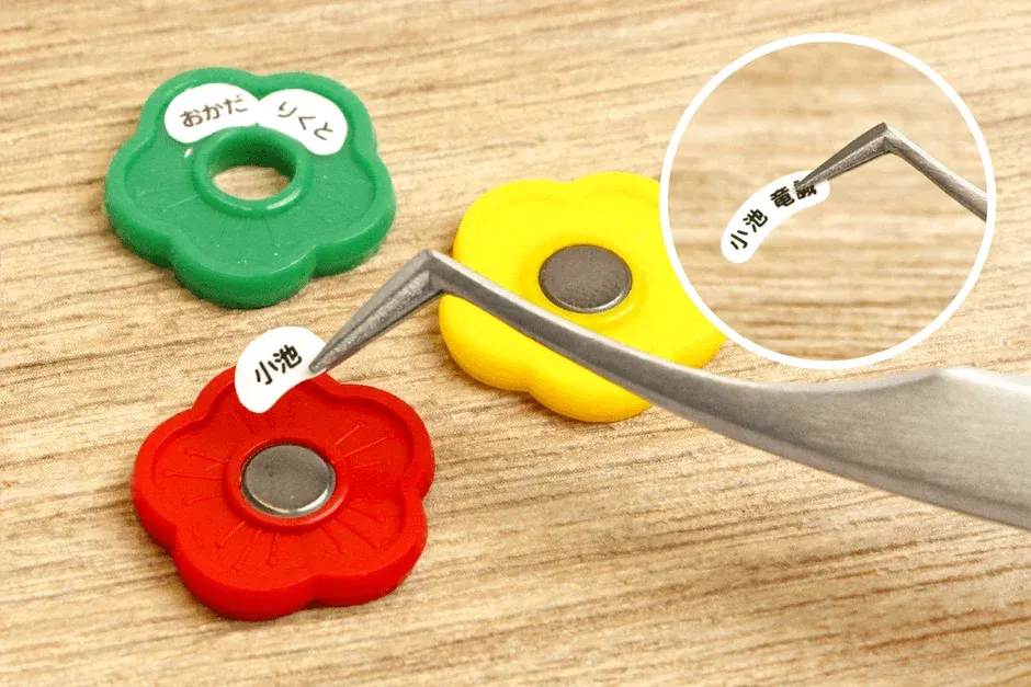 ピンセットでお名前シールを貼る様子