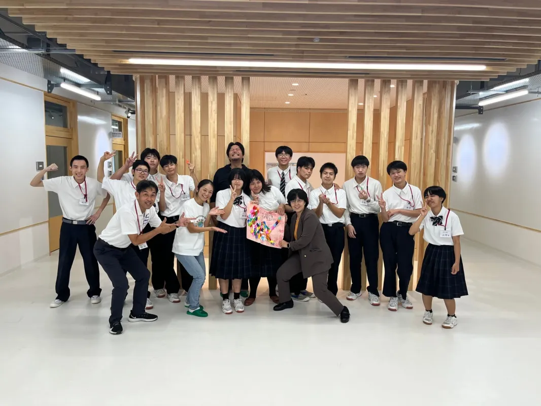 生徒と大人が作品を持って集合写真