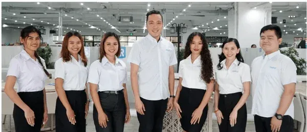 白いシャツと黒いボトムスを着用した7人の男女の集合写真