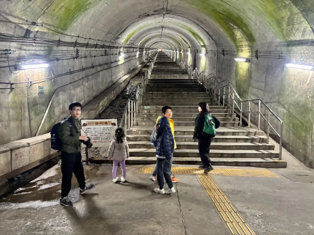 古いトンネルの階段を探検する人々