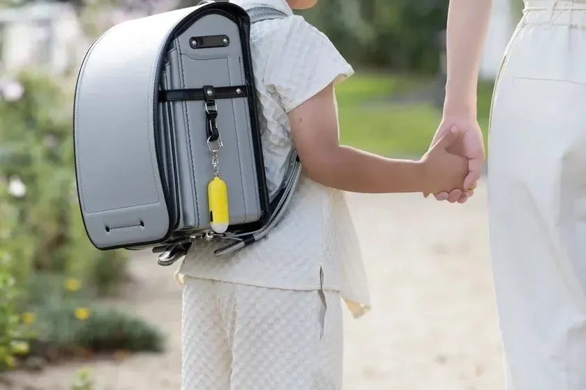 子供が大人と手をつないで歩く後ろ姿