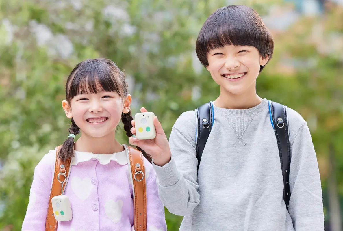 ランドセルを背負った小学生の兄妹とデバイス