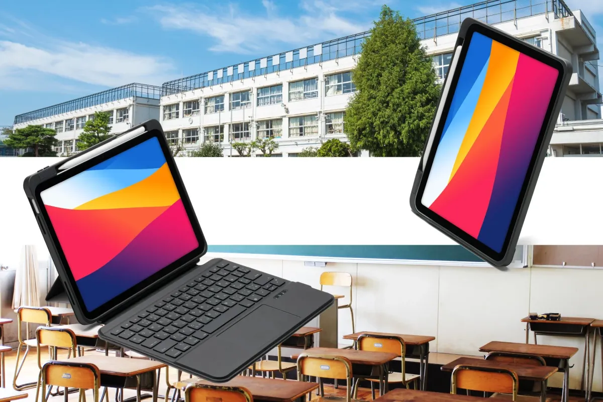 日本の学校の校舎と空の教室を背景に、キーボードケースとApple Pencilが装着された2台のタブレットが浮かんでいます。現代の教育や学習環境を象徴するイメージです。
