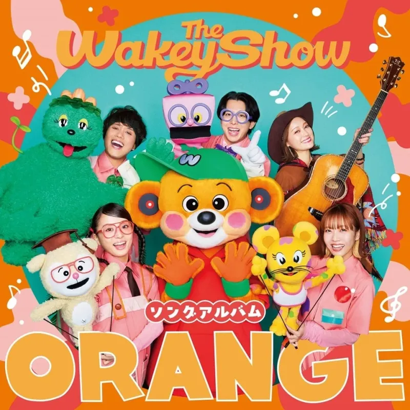 「The Wakey Show ORANGE」と書かれたアルバムジャケットで、複数の出演者と可愛らしいマスコットキャラクターたちが笑顔でポーズをとっています