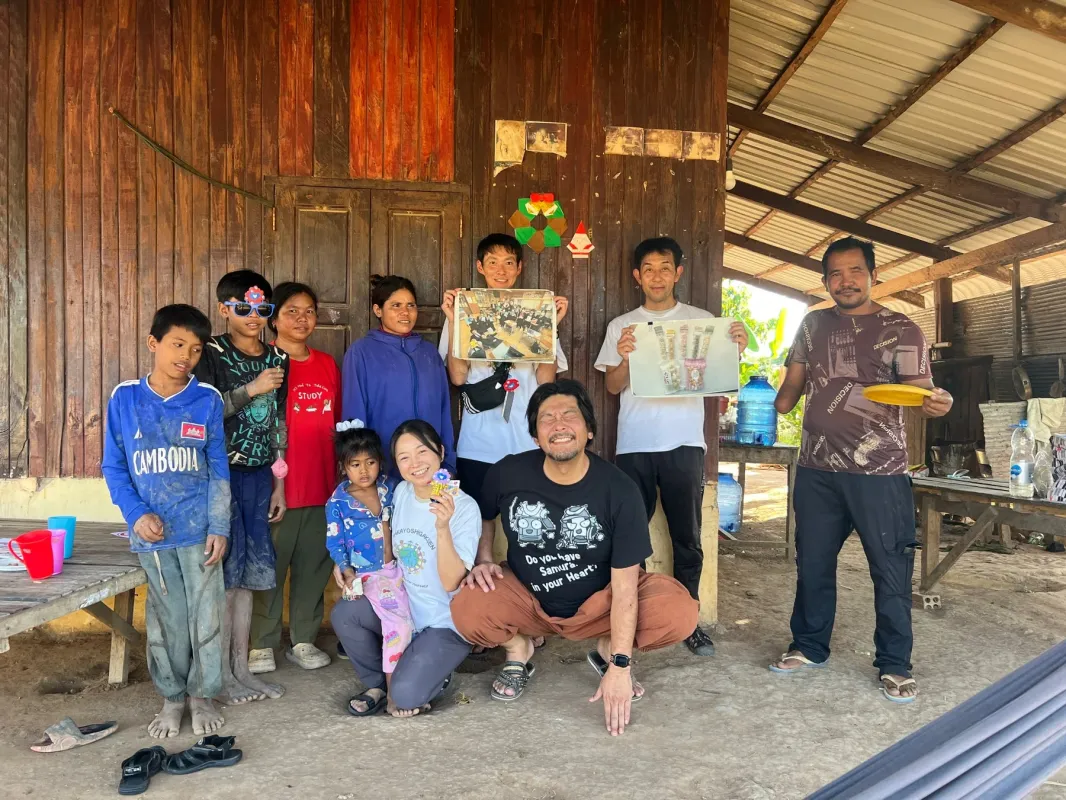 木造家屋の前で交流する大人と子供たち