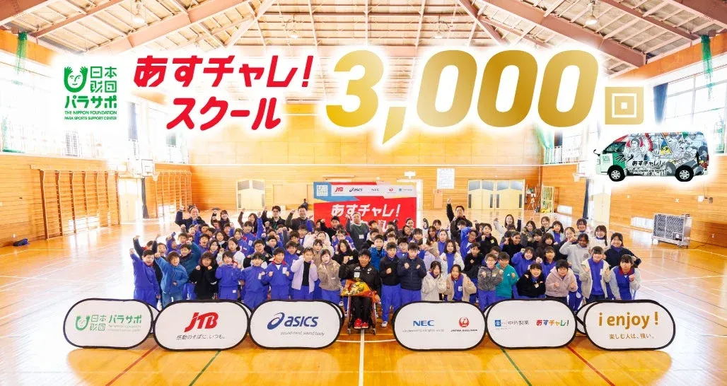 体育館で大勢の児童と大人、車いすの参加者が「あすチャレ!スクール」の3,000回達成を祝っている集合写真