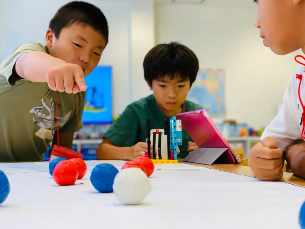 子供たちがロボットとタブレットで学習