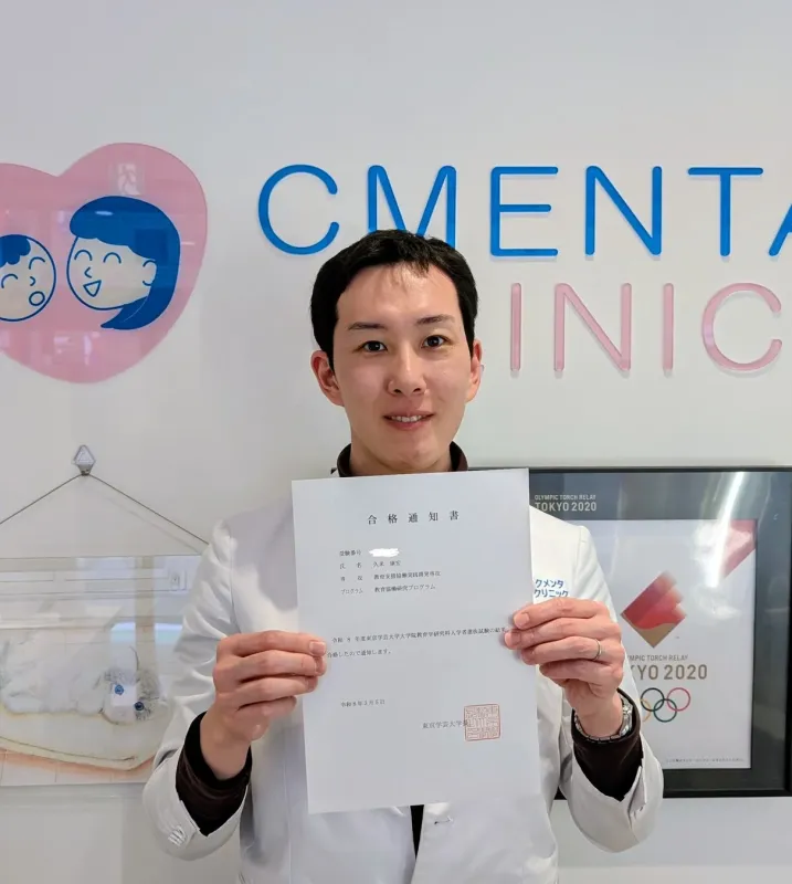 久米康宏医師が東京学芸大学大学院の合格通知書を掲げる様子