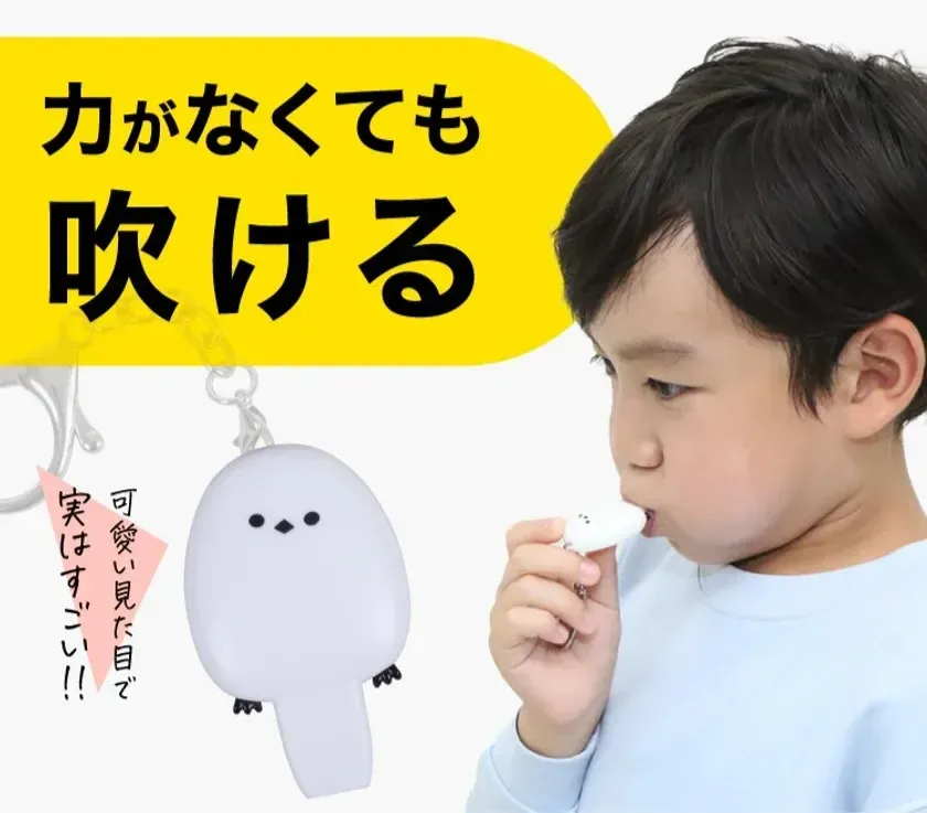 子供がシマエナガの形をした防犯ブザーを吹いている